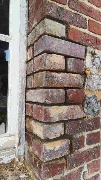 Réparation de gonds sur une façade en brique et silex par nos artisans maçons à Yport 76
